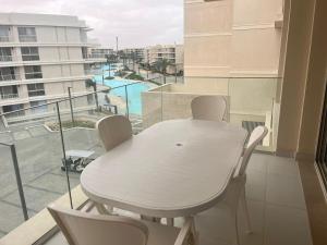 a white table and chairs on a balcony with a view at Marassi in El Alamein