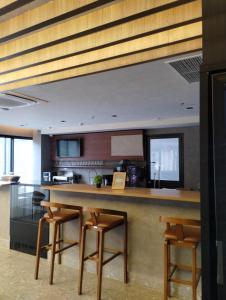 a kitchen with a table and some stools at Sky Design Alphaville Hotel Residence in Barueri
