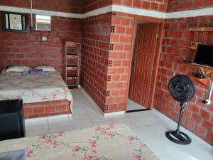 a bedroom with a bed and a brick wall at Chalé 02 Cantinho do Céu- Santo Amaro do MA in Santo Amaro