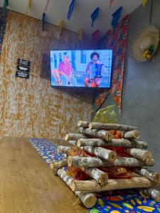 a room with a television and a table with logs at A 3,3 km do Parque do Povo in Campina Grande