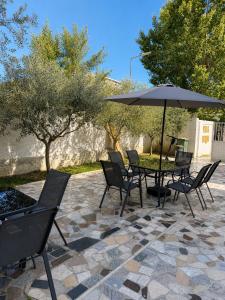 a table and chairs with an umbrella on a patio at Vila Beqja in Durrës