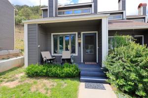 a house with a front porch with a table and a chair at Pine Acres 109 - Hideaway in Durango