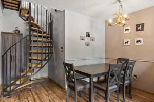 a dining room with a table and chairs and a spiral staircase at Pine Acres 109 - Hideaway in Durango +18 photos