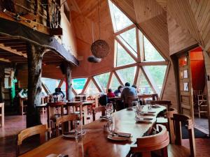 a restaurant with people sitting at tables in a room with windows at Centro Turistico Vortice Chile in Manzanar