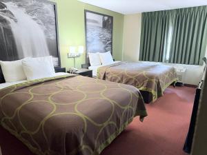 a hotel room with two beds and a couch at Super 8 by Wyndham Fond Du Lac in Fond du Lac +14 photos