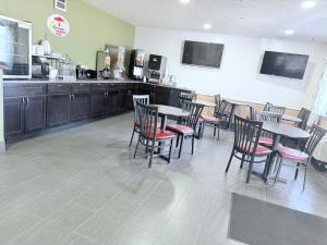 a restaurant with tables and chairs and a kitchen at Super 8 by Wyndham Fond Du Lac in Fond du Lac