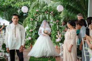 a bride walking down the aisle with her father at Alzurich Private Resort in Dauin