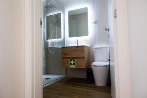 a bathroom with a sink and a toilet and a mirror at O Vilarealense Heritage Apartment in Vila Real +42 photos