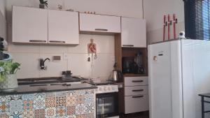 a kitchen with white cabinets and a white refrigerator at Vivendas Raízes do forte in Praia do Forte