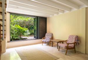 a room with two chairs and a table and a window at Harmony Creek - The Cottage in Cow Bay