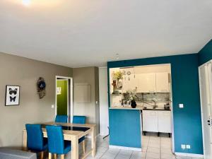 a kitchen and dining room with a table and blue chairs at AMOUR PARIS -Orly 10min Bus -RER C Tram T9 in Vitry-sur-Seine