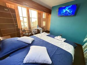 a bedroom with a blue bed with two white pillows at Hotel Elom in Uyuni
