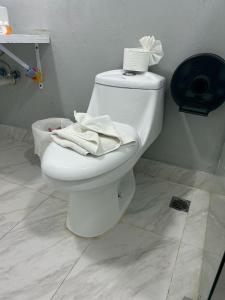 a bathroom with a white toilet with towels on it at Hannabi Hotel in Boca Chica +7 photos
