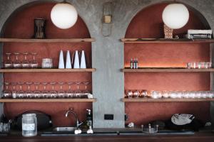 a kitchen with shelves with glasses and a sink at UNÚ Beach Hotel in Palomino