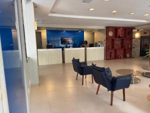 a lobby with chairs and a table and a counter at Flat Recife - Boa Viagem in Recife +38 photos