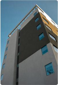 ein hohes Gebäude mit blauen Fenstern an der Spitze in der Unterkunft Hotel Curico - Ex Radisson Curico in Curicó