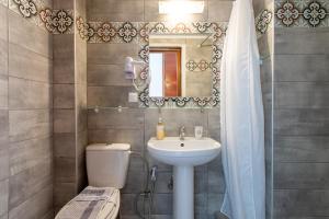 a bathroom with a sink and a toilet and a mirror at Erofili Rooms in Agia Galini +61 photos