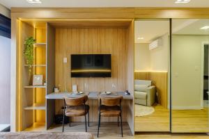 a room with a table with chairs and a television at Soul República - Cidade Baixa in Porto Alegre