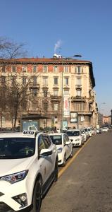 una fila de autos blancos estacionados frente a un edificio en Appartamento San Michele, en Milán