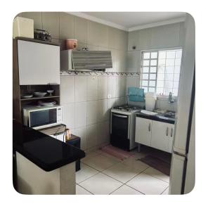 a small kitchen with a stove and a sink at Raquel in Londrina