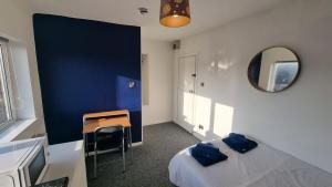 a bedroom with a bed and a desk and a mirror at Self-Contained Studio Private Bathroom Sleeps 2 in Nottingham
