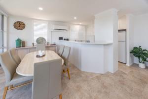 a kitchen and dining room with a table and chairs at Beach Street Oasis - Tuncurry in Tuncurry