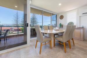 a dining room with a table and chairs at Beach Street Oasis - Tuncurry in Tuncurry