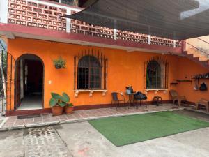 an orange building with a green rug in front of it at Casa Nimacachi in Panajachel +4 photos