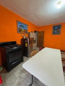 a kitchen with a white table and a refrigerator at Casa Nimacachi in Panajachel