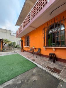 a patio with a table and chairs next to a building at Casa Nimacachi in Panajachel