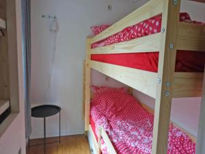 a bedroom with two bunk beds with red sheets at Vechtdal Chalet de Berk in Rheezerveen