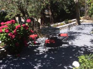 a table and chairs next to some pink flowers at Sweet Caselle in Testico