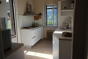 a small kitchen with white cabinets and a sink at Sweet Caselle in Testico