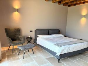 a bedroom with a large bed and a chair at Elegant suite with shared pool in Adro +26 photos