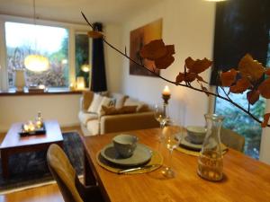 a living room with a wooden table with a vase with flowers at Vechtdal Chalet de Eik in Rheezerveen +10 photos
