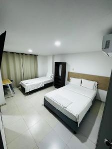 a hotel room with two beds and a table at Torre 2 Bucare in Yopal