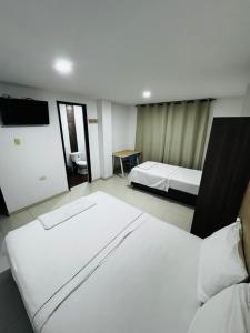 a hotel room with two beds and a flat screen tv at Torre 2 Bucare in Yopal +24 photos