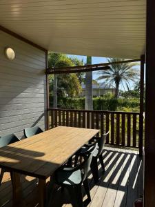 a wooden table and chairs on a deck at Auberge de Poé in Bourail