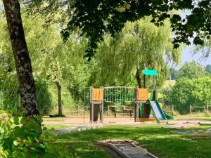 a playground with a slide in a park at Cozy Cottage Retreat for Two in Moutiers-sous-Chantemerle