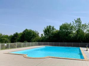 a swimming pool in a backyard with a fence at Cozy Cottage Retreat for Two in Moutiers-sous-Chantemerle