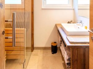 a bathroom with a sink and a glass shower at Spacious suite for 8 guests with a private sauna in Rauris +22 photos