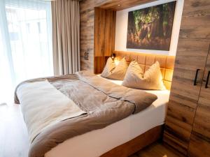 a bedroom with a large bed with a painting on the wall at Spacious suite for 8 guests with a private sauna in Rauris