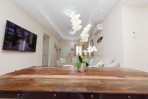a living room with a wooden table with flowers on it at Oceanpointe Luxury Retreat-3 Bedroom Home in Point