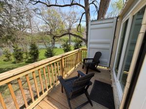 a porch with two chairs and a house at Romantic Riverfront Retreat in Sugar Run