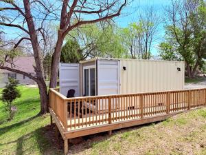 a tiny house with two doors on a deck at Romantic Riverfront Retreat in Sugar Run