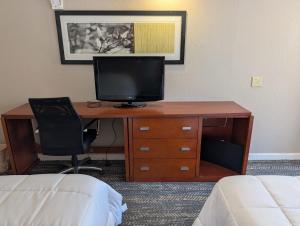 a desk with a computer on it in a hotel room at Exceed Inn Indianapolis Airport South in Indianapolis