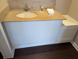 a bathroom sink with a granite counter top at Exceed Inn Indianapolis Airport South in Indianapolis