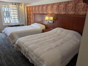a hotel room with two beds and a window at Exceed Inn Indianapolis Airport South in Indianapolis