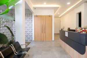 a lobby with a wooden door and a desk at Urbanview Hotel Subali Purwokerto in Purwokerto