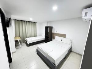 a hotel room with two beds and a television at Torre 2 Bucare in Yopal